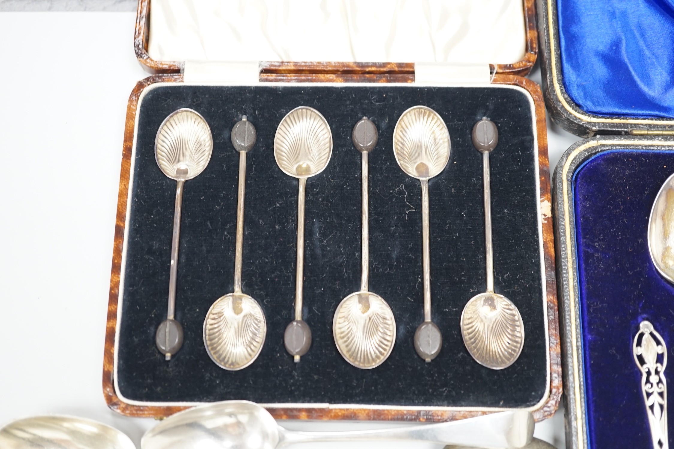 A cased set of twelve George V pierced silver teaspoons, with tongs, Sheffield, 1910, one other cased set of six silver bean end coffee spoons and eleven assorted mainly 19th century silver teaspoons.